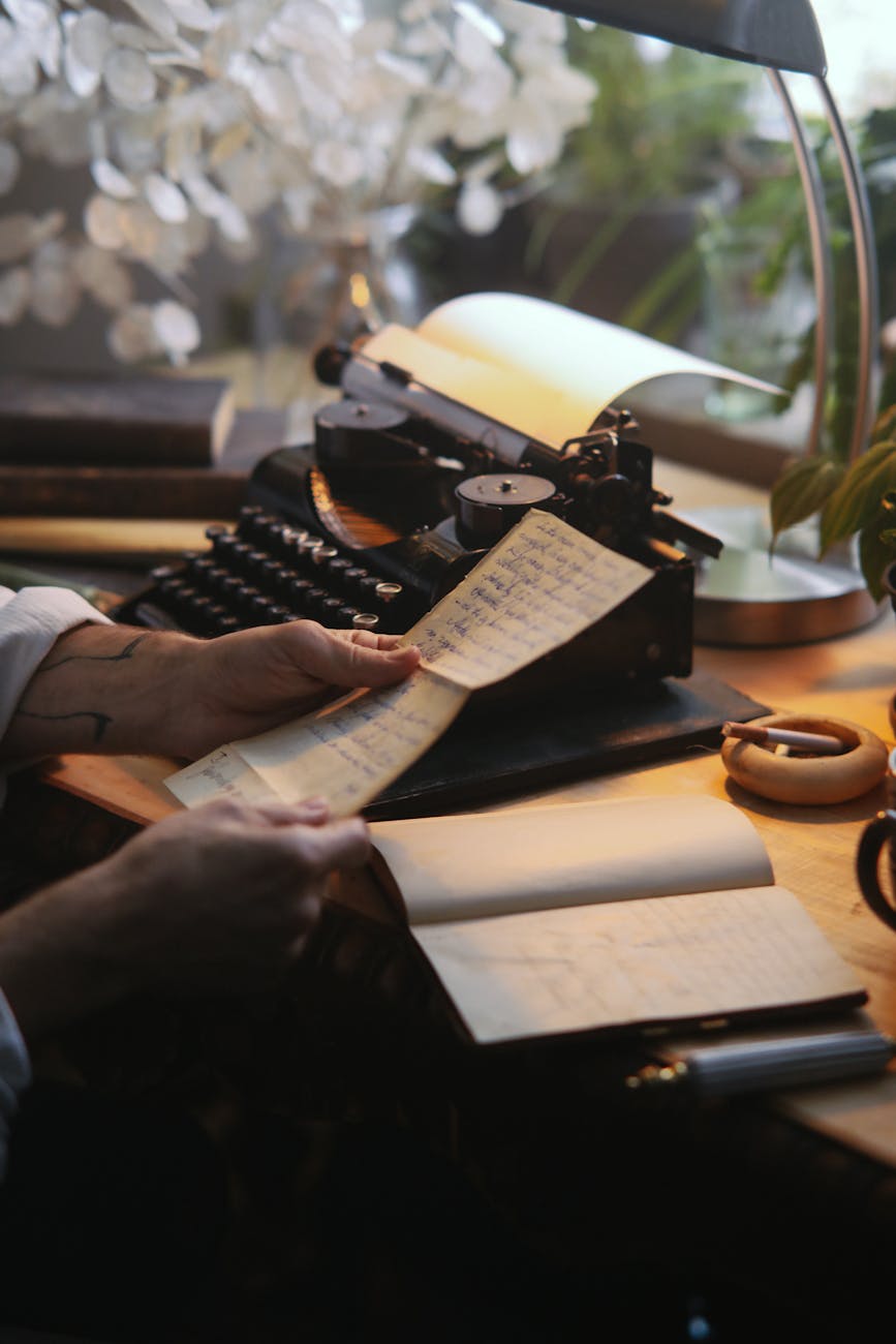 A picture of a person reading an old letter with a typewriter in the background